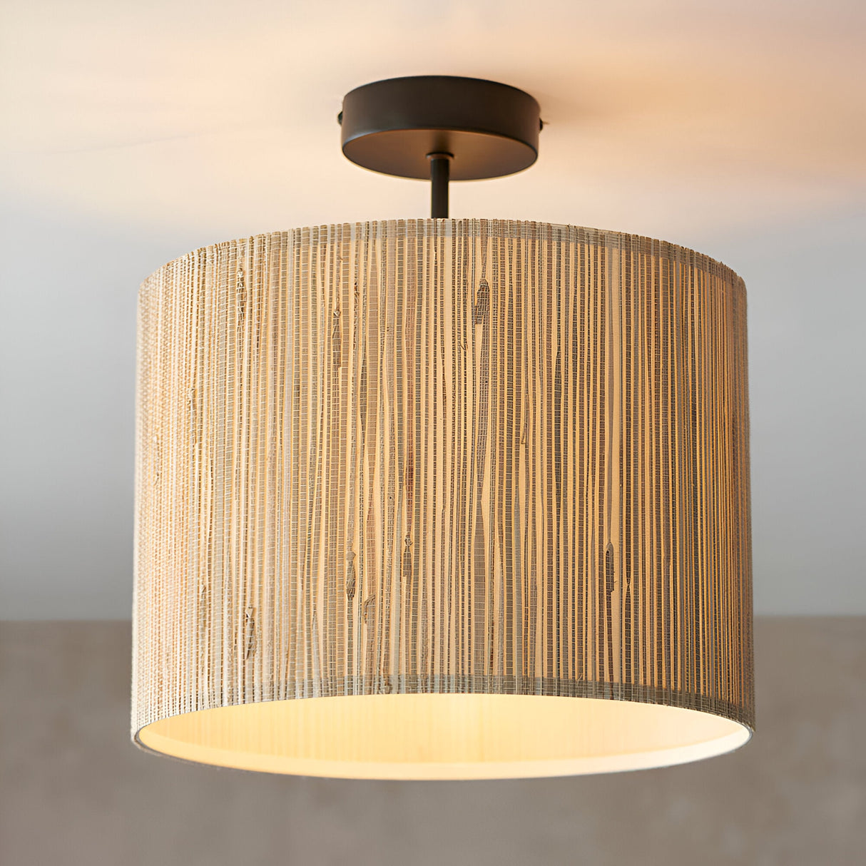 Endon Salcombe semi-flush ceiling light with woven seagrass drum shade and matt black metal fitting, illuminated against a neutral background.