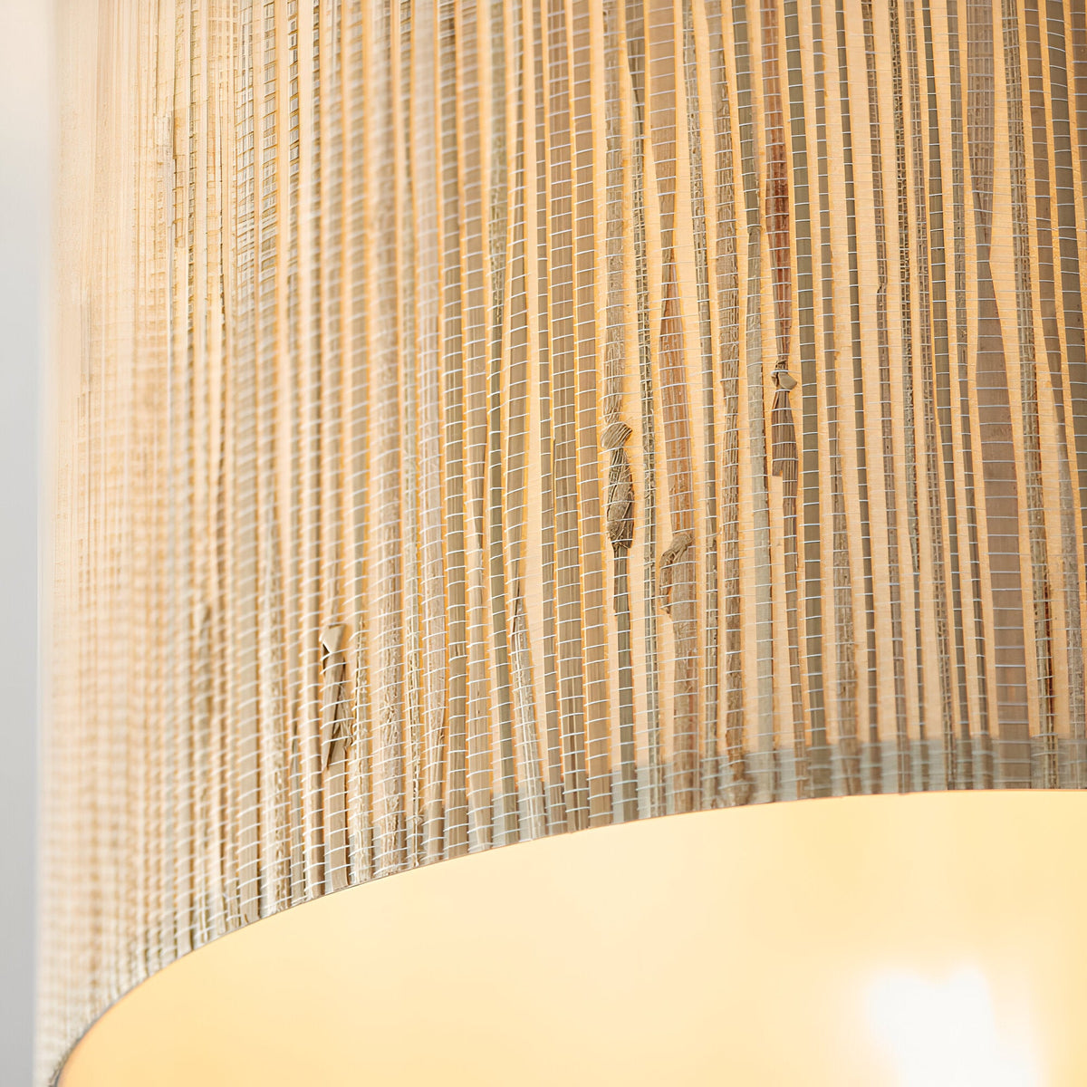 Close-up of the Endon Salcombe semi-flush ceiling light showing the woven seagrass shade texture and warm glow from the E27 lamp within.
