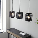 Endon Bracken 3 light pendant with matt black bamboo cage shades and E27 filament bulbs, hung above a dark console table in a bright living space.