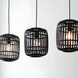 Endon Bracken 3 Light Pendant in black with three linear bamboo cage shades and exposed filament bulbs against a plain white background.