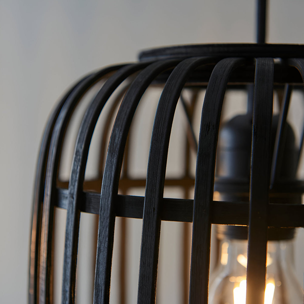 Close-up of Endon Bracken 3 Light Pendant in black, showing the dark-stained bamboo cage framework and warm filament E27 lamp within.