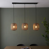Endon Bracken 3 Light Pendant in black and natural, three bamboo cage shades on a linear bar with exposed filament bulbs above a dining table.