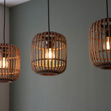Endon Bracken pendant lights with natural bamboo cage shades and matt black fittings, each holding a lit E27 filament bulb against a soft grey wall.