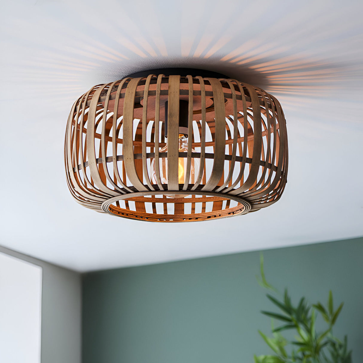Endon Bracken bamboo flush ceiling light in natural finish, woven drum shade with single E27 lamp casting a striped glow across the ceiling.