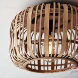 Endon Bracken bamboo flush ceiling light in a natural woven finish, shown close up with a single E27 lamp glowing inside the rounded shade.