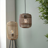 Endon Bracken pendant light with natural bamboo cage shade and matt black flex, shown beside a matching bamboo floor lamp against a sage green wall.