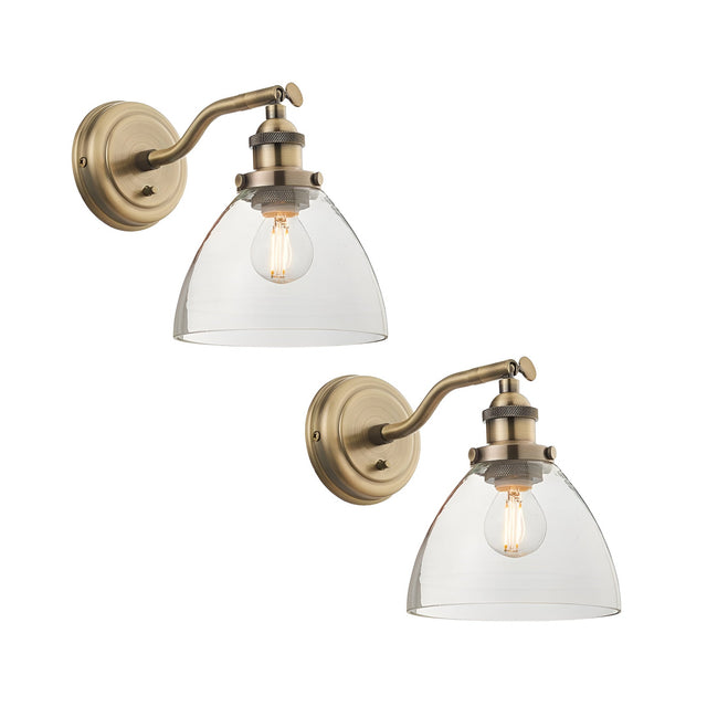 Wentworth Wall Light in antique brass, twin pack shown, each with an adjustable arm, knurled fitting, and clear glass dome shade over a filament bulb, on a plain white background.