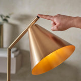 Endon Ashworth brass floor lamp with a conical shade and adjustable arm, shown as a hand presses the push switch near the top.