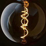 Endon 4W E27 LED filament bulb with amber tinted glass globe and illuminated warm white spiral filament glowing at 2000K.