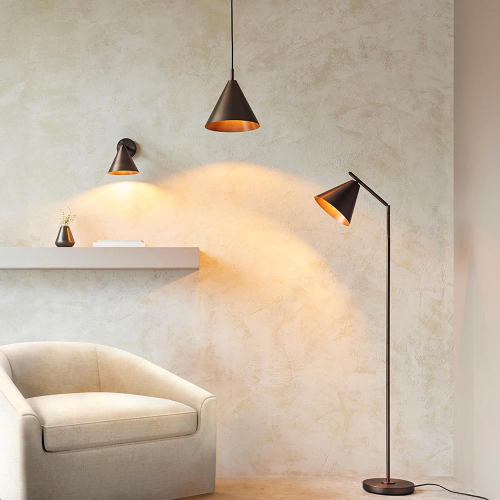 Endon Ashworth bronze pendant lit above a shelf, shown with a matching wall light and floor lamp against a warm plaster wall in a living room.