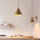 Endon Ashworth brass pendant and matching cone wall light with adjustable arm, illuminating a dining nook with plaster walls and a wooden shelf.