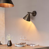 Endon Ashworth bronze wall light with adjustable arm and conical shade, illuminating a dining console with vase, glasses and plates.