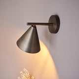 Endon Ashworth wall light in bronze with a conical shade on an adjustable arm and round backplate, casting a warm glow on a pale wall.