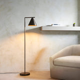 Ashworth Floor Lamp in bronze, single-light design with angled arm and cone shade, shown lit beside a sofa in a living room setting.