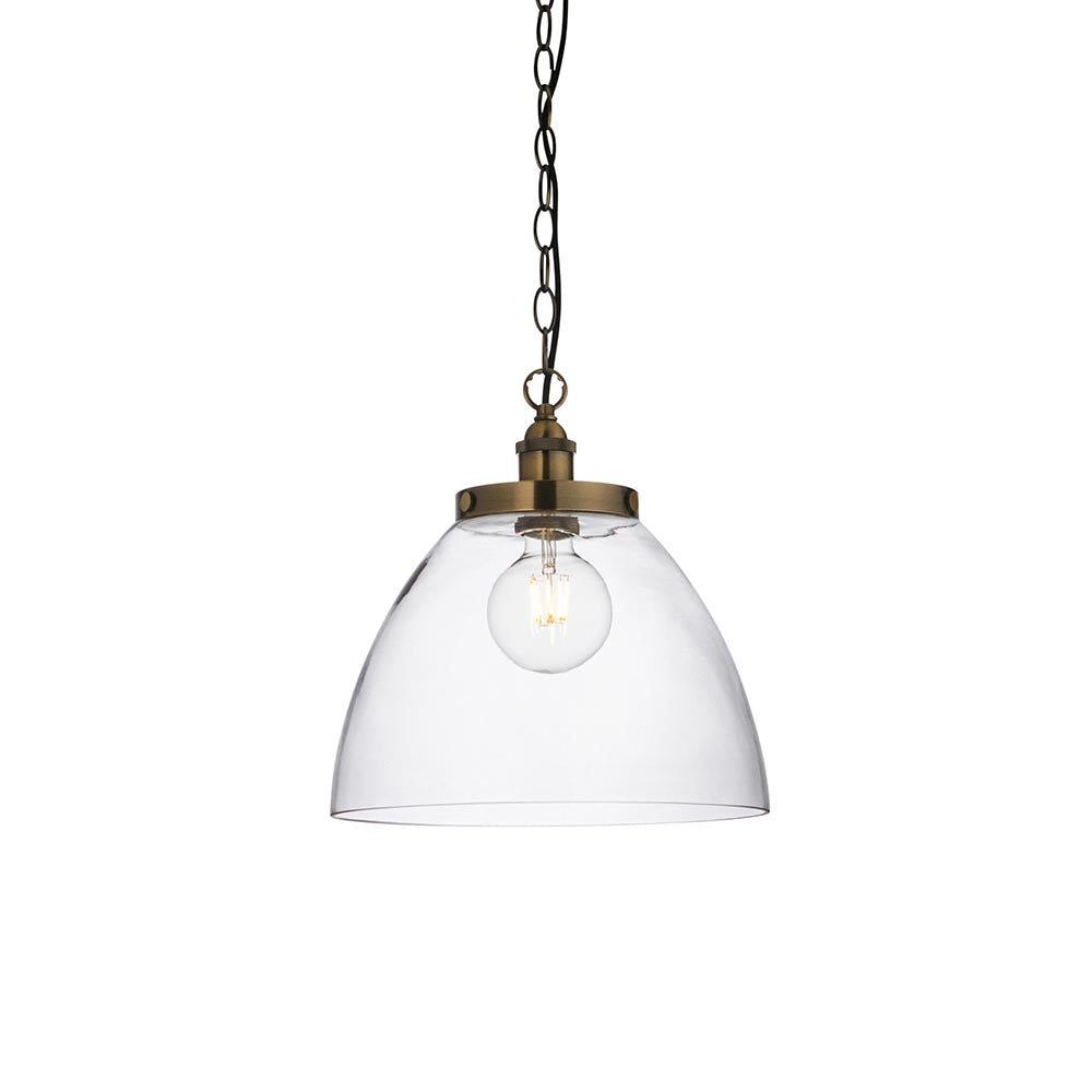 Wentworth Pendant in brass with a clear glass dome shade, knurled lampholder, visible filament bulb, and black chain, shown on a plain white background.