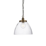 Wentworth Pendant in brass with a clear glass dome shade, knurled lampholder, visible filament bulb, and black chain, shown on a plain white background.