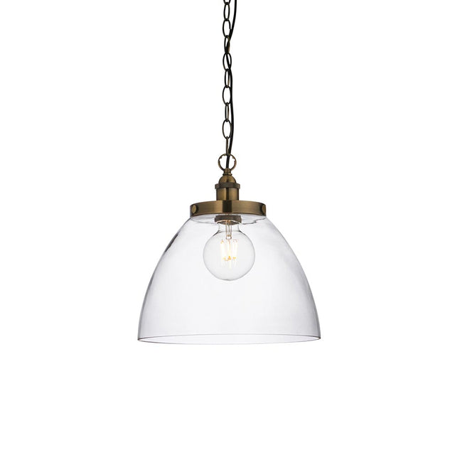 Wentworth Pendant in brass with a clear glass dome shade, knurled lampholder, visible filament bulb, and black chain, shown on a plain white background.