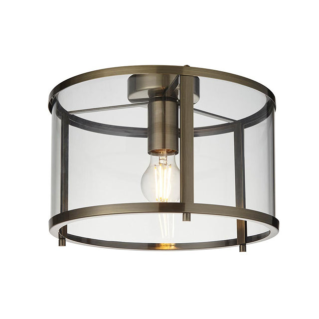 Endon Ellery flush ceiling light in brass with a cylindrical clear glass shade and single E27 exposed filament bulb, shown on a plain white background.
