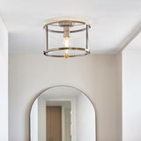 Endon Ellery flush ceiling light in brass with a cylindrical clear glass shade and single E27 bulb, mounted above an arched mirror in a bright hallway.