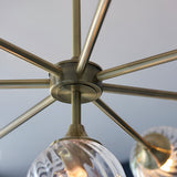 Close-up of Endon Georgiana 8 light pendant showing antique brass spoked frame and a spiral-cut clear glass shade below.