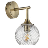 Georgiana brass wall light with single arm, round wall plate, and spiral-pattern clear glass globe shade showing an E14 bulb.
