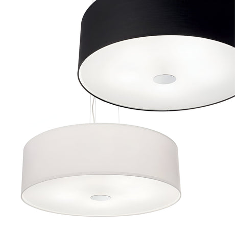 The Noble 5 Light Pendant - White features a modern design with two cylindrical shades suspended from a chromed metal frame. The top pendant showcases a black shade, while the bottom highlights a white shade. Both shades hang on adjustable-length cables, providing a soft and even illumination.