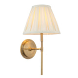 Endon Chartwell wall light with tapered box-pleat cream cotton shade on an antique brass bracket, single E14 fitting, shown on a white background.