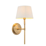 Endon Chartwell wall light with a tapered ivory fabric shade and slim antique brass bracket with round wall plate, shown on a plain white background.