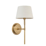 Endon Chartwell wall light with a tapered ivory fabric shade on a slim antique brass bracket and round wall plate, shown against a white background.