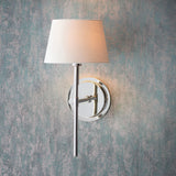 Endon Chartwell wall light with slim nickel bracket and tapered ivory fabric shade, illuminated against a distressed blue-grey wall.