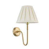 Endon Cliffdon wall light in antique brass with a curved arm and cream box-pleat tapered fabric shade, shown on a plain white background.