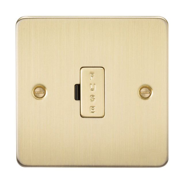 The 13A Fused Spur Unit - Brushed Brass (Flat Plate) showcases an ultra-low profile design with two visible screws and FUSE elegantly engraved on the central switch.