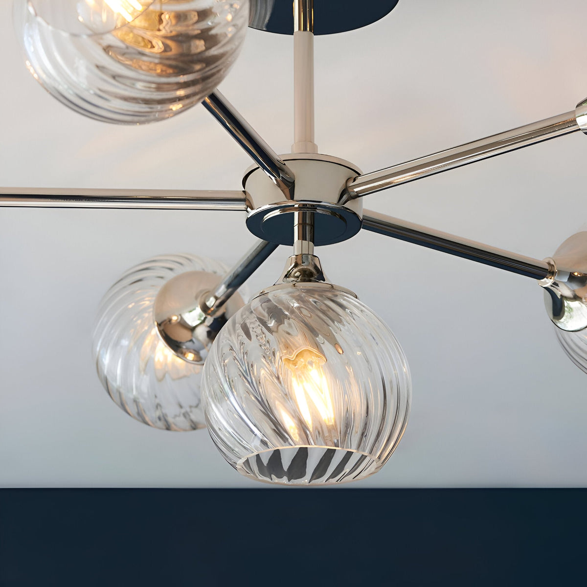Close-up of the Georgiana 6 Light Semi-Flush Ceiling Light in nickel, showing ribbed glass globe shades on chrome arms radiating from a central plate.