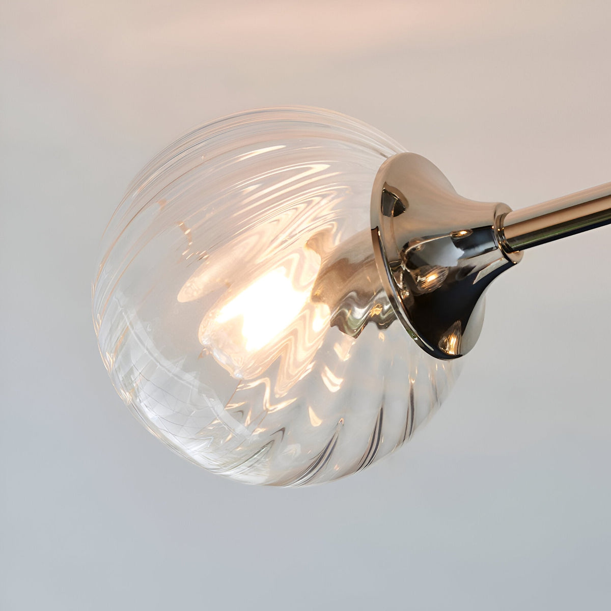 Close-up of the Georgiana 6-Light Semi-Flush Ceiling Light in nickel, showing a swirled glass globe shade with lit bulb on a nickel arm.