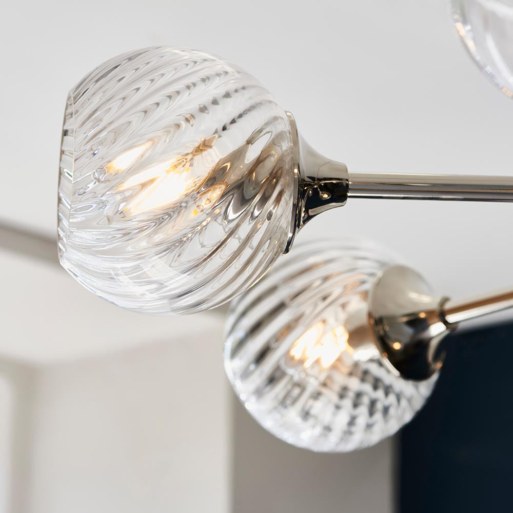 Close-up of Endon Georgiana 8 Light Pendant in nickel, showing spiral-cut clear glass globe shades with lit E14 lamps on polished nickel arms.