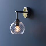 Endon Georgiana wall light in nickel with a spiral-patterned clear glass globe shade and E14 bulb, mounted on a deep blue wall.