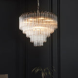 Endon Cranshaw 12 light tiered pendant with ribbed clear glass cylinders and polished chrome metalwork, suspended from a chain against a dark panelled wall.