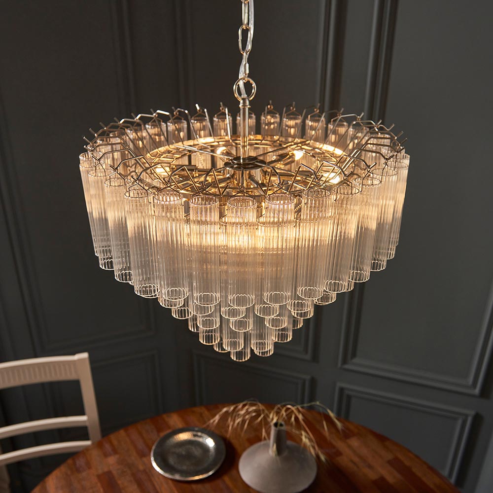 Endon Cranshaw 12 light tiered pendant in polished chrome with layered ribbed clear glass tubes, suspended by chain above a wooden dining table.
