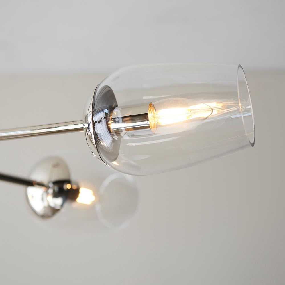 Close-up of Endon Caldworth 6 Light Pendant in nickel, showing a clear blown glass shade with lit E14 lamp and slender chrome arm against a pale background.