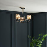 Clementine 3 Light Semi-Flush Ceiling Light in nickel with faceted glass shades, shown mounted in a corner against dark panelled walls.