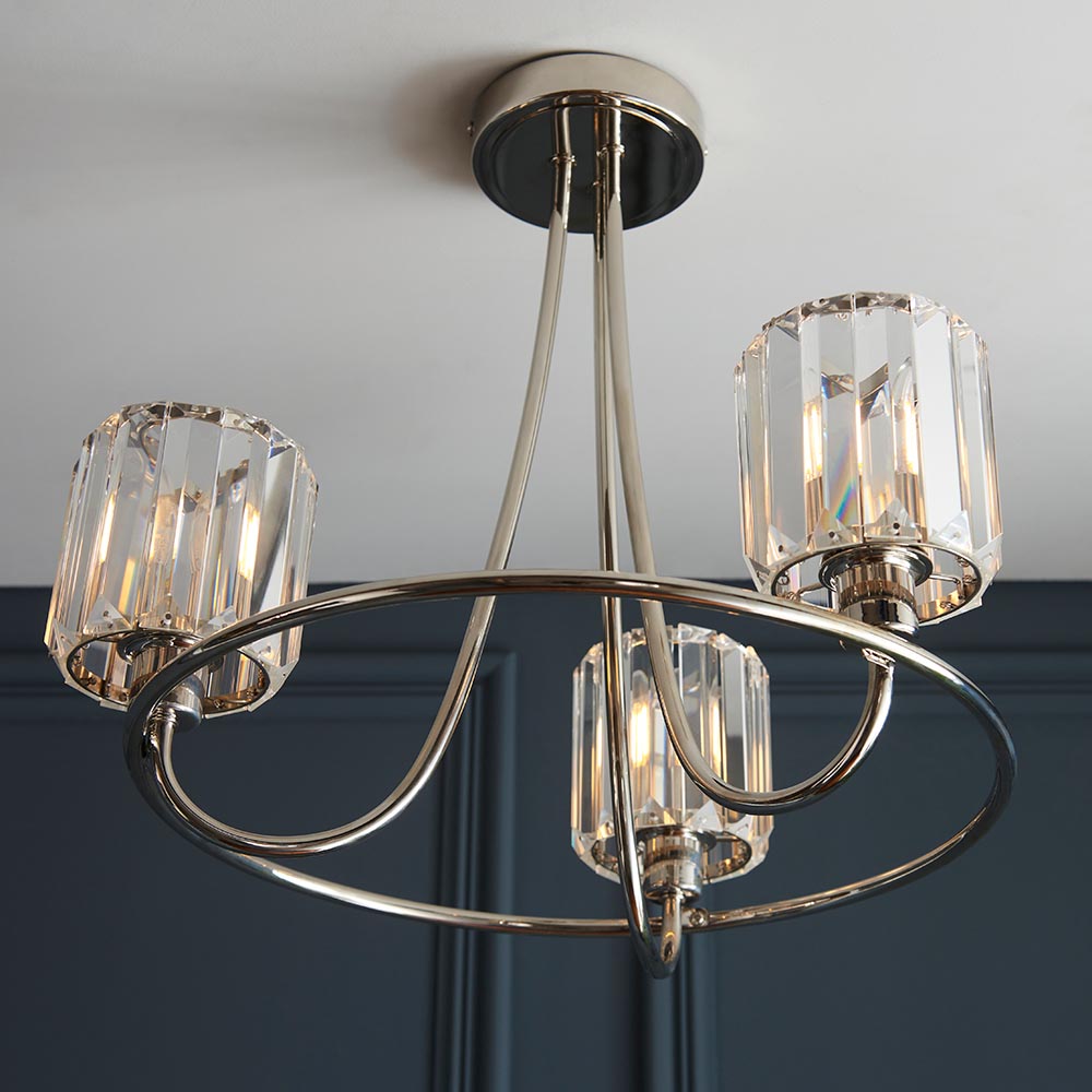 Clementine 3 Light Semi-Flush Ceiling Light in nickel, featuring a circular frame with three faceted glass shades, mounted on a dark ceiling in a room setting.