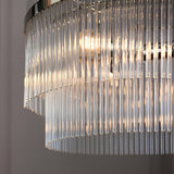Close-up of the Beaumont 3 Light Pendant in nickel, showing tiered clear glass rods diffusing light from visible bulbs, with a chrome frame above.