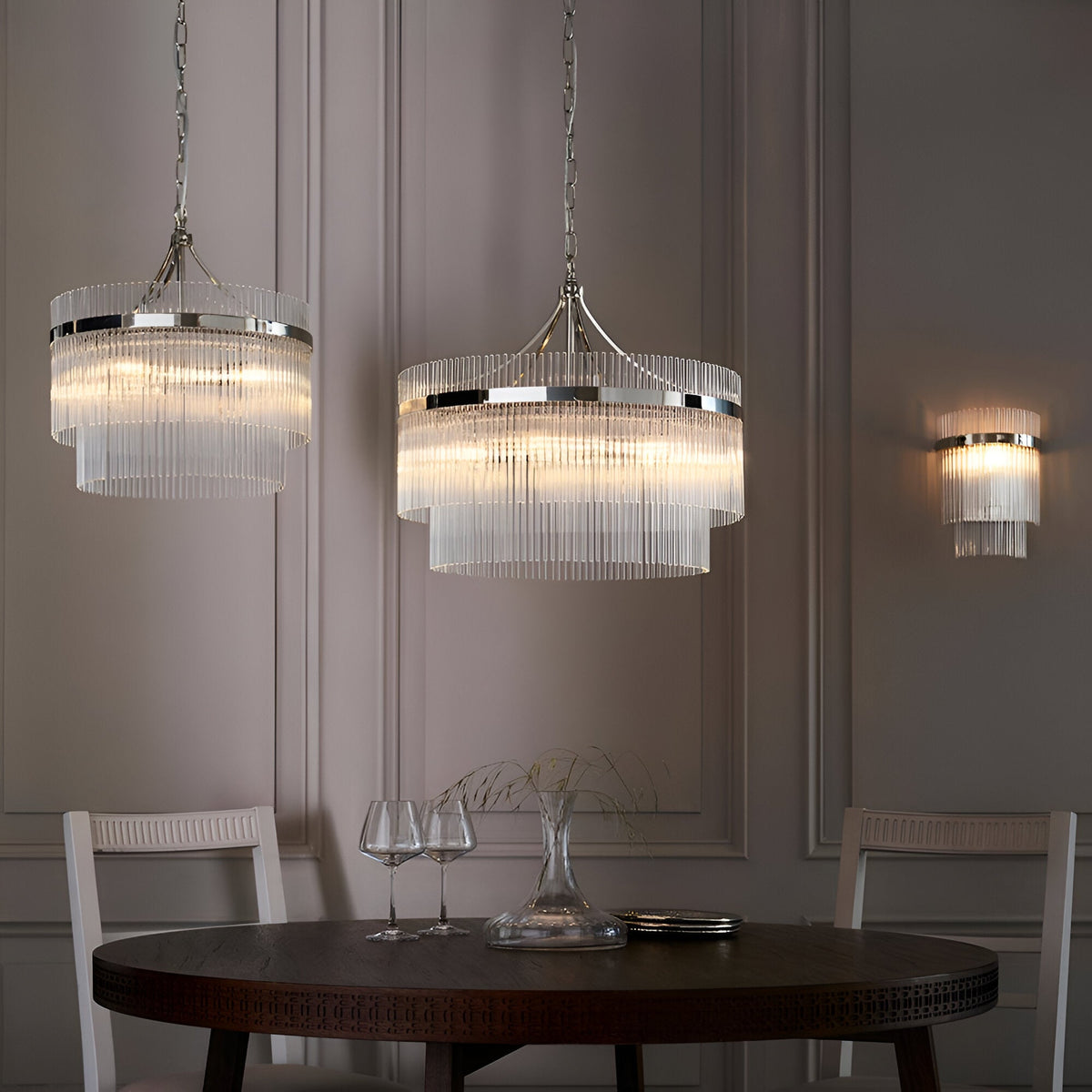 Beaumont 3 Light Pendant in nickel with tiered clear glass rods, shown hanging above a dining table alongside a matching wall light.