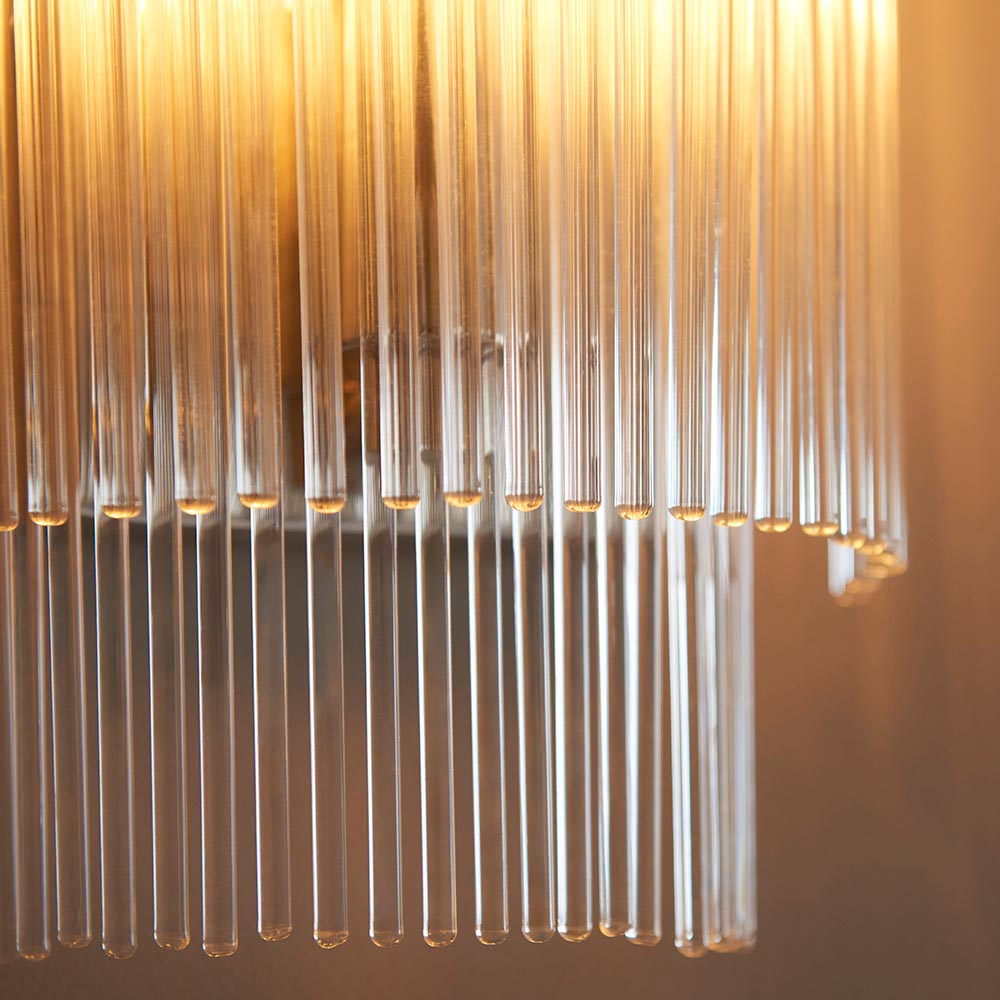 Close-up of Endon Beaumont wall light in nickel showing clear glass rods in tiered rows glowing warmly around the E14 lamp.
