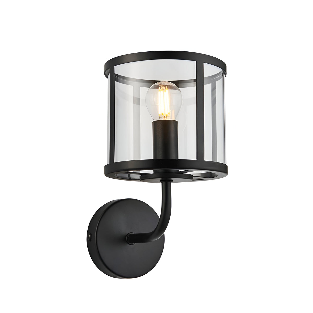 Endon Ellery wall light in matt black with a clear cylindrical glass shade, curved arm, round backplate and single E14 filament bulb.