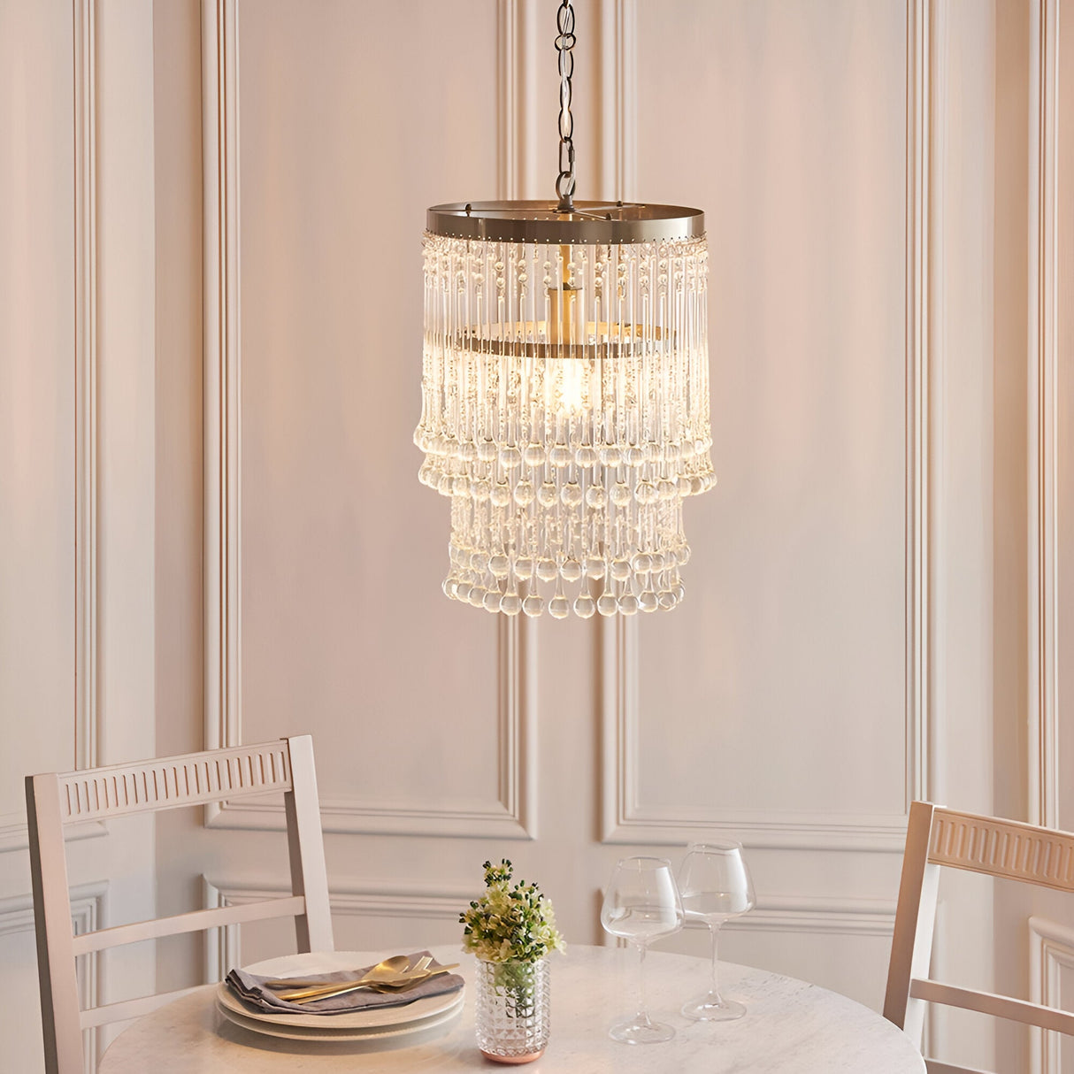 Bramgrove tiered pendant light with clear glass droplets on an antique brass frame, hanging above a dining table in a panelled room.