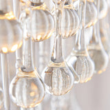Close-up of the Bramgrove Pendant in antique brass, showing clear glass droplets catching warm light for a soft sparkle effect.