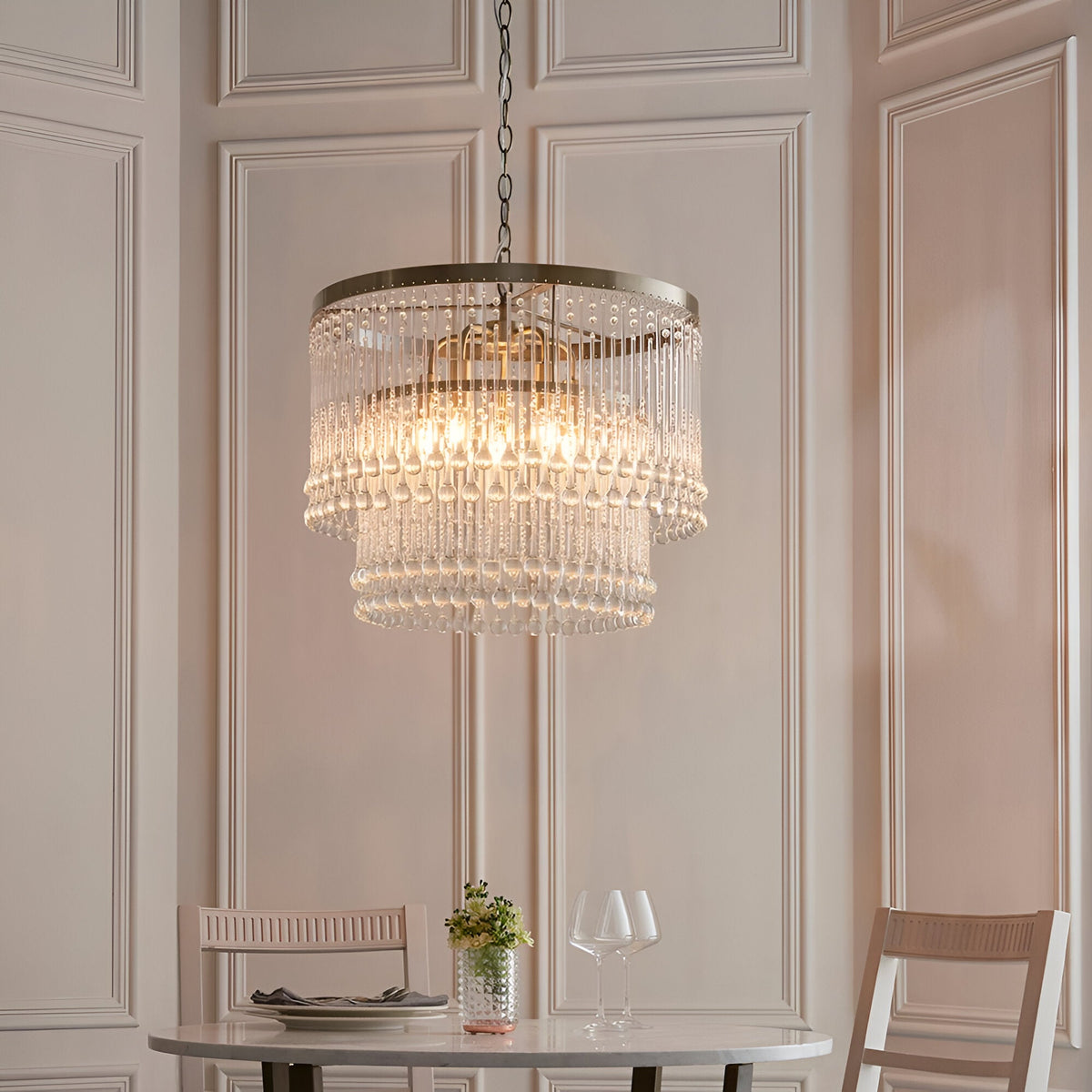 Endon Bramgrove 5 light pendant with tiered clear glass droplets on an antique brass frame, hung above a dining table in a panelled room.