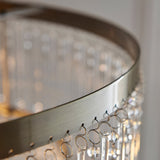 Close-up of the Endon Bramgrove pendant showing the antique brass frame rim and tiered clear glass droplets suspended below.