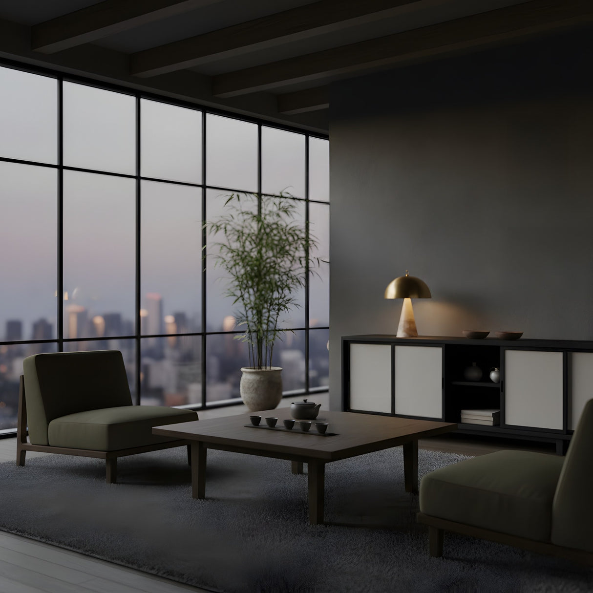 A modern, minimalist living room with floor-to-ceiling windows overlooking a cityscape at dusk features low chairs, a wooden coffee table with tea set, potted plant, and the Viren 2 Light Polished Cap Alabaster Table Lamp in Brushed Bronze & Soft White on a sideboard.